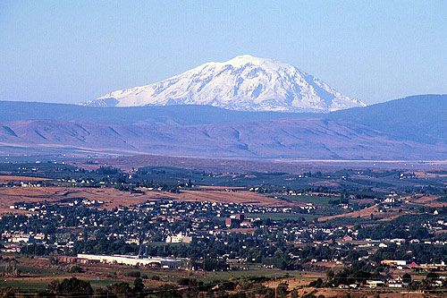 The Yakima skyline with a  snow-capped mountain in the background that is a little hazy from air pollution.