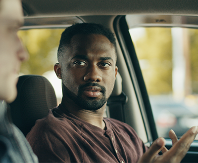 Imagen de hombres jóvenes hablando en un vehículo del comercial de la campaña