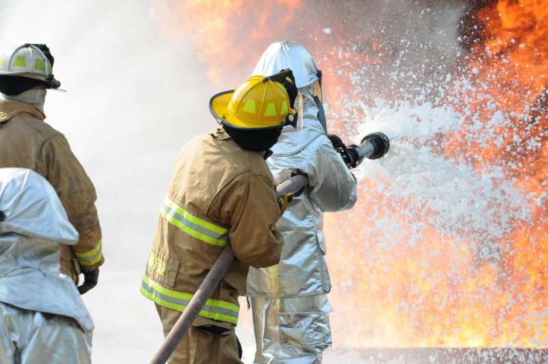 Firefighters using a firefighting foam to stop a fire.